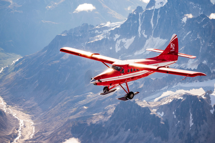 a plane flying over a snow covered mountain